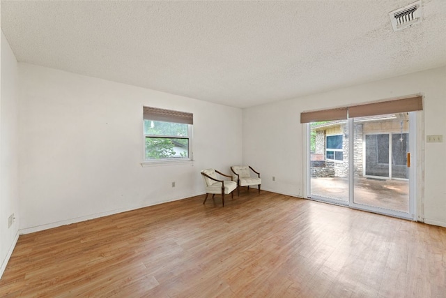 600 Little Oak Dr, Austin, TX 78753 - spare room featuring light wood-style flooring, healthy amount of natural light, and a textured ceiling