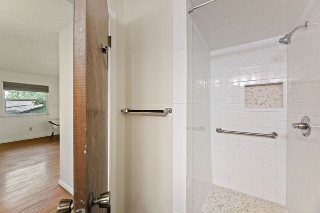 600 Little Oak Dr, Austin, TX 78753 - bathroom featuring tiled shower and wood finished floors