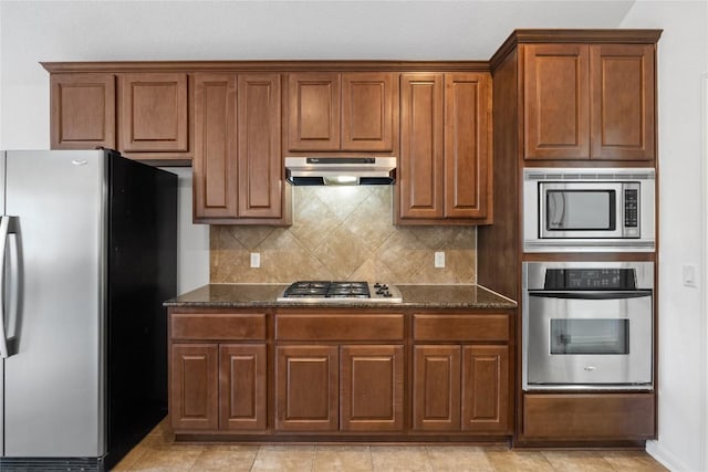 250 Maeves Way, Austin, TX 78737 - kitchen featuring appliances with stainless steel finishes, under cabinet range hood, dark stone countertops, and tasteful backsplash