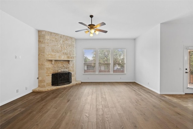 250 Maeves Way, Austin, TX 78737 - unfurnished living room featuring ceiling fan, wood finished floors, plenty of natural light, and a stone fireplace