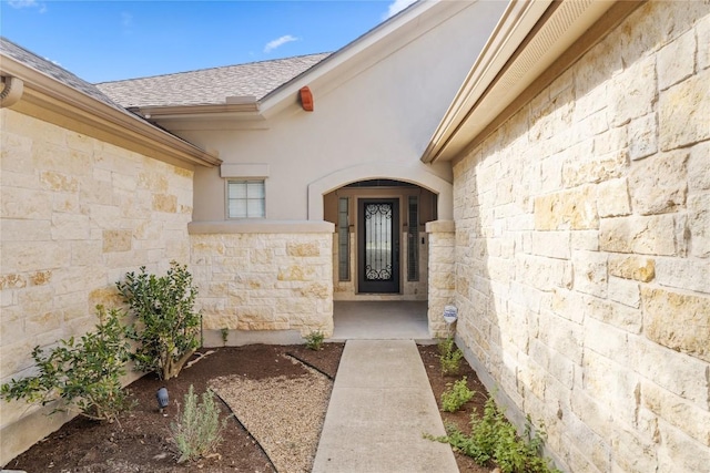 250 Maeves Way, Austin, TX 78737 - property entrance with stone siding, a shingled roof, and stucco siding