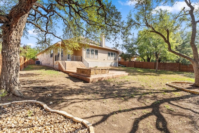 250 Maeves Way, Austin, TX 78737 - back of property with a fenced backyard, a chimney, and cooling unit