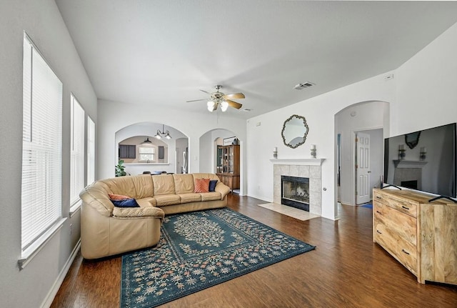 808 N Creek Blvd, Leander, TX 78641 - living room featuring a tiled fireplace, a ceiling fan, dark wood-type flooring, and plenty of natural light