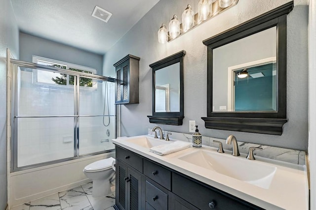 808 N Creek Blvd, Leander, TX 78641 - bathroom with toilet, marble look tile flooring, double vanity, and combined bath / shower with glass door