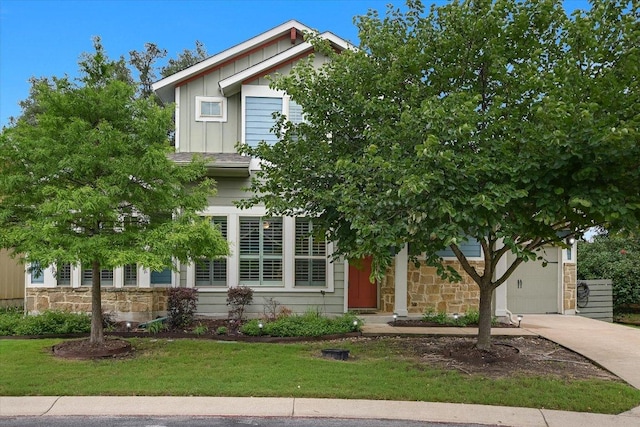 10908 Railway Ln Unit 76, Austin, TX 78717 - view of property hidden behind natural elements with board and batten siding, stone siding, concrete driveway, a front yard, and an attached garage