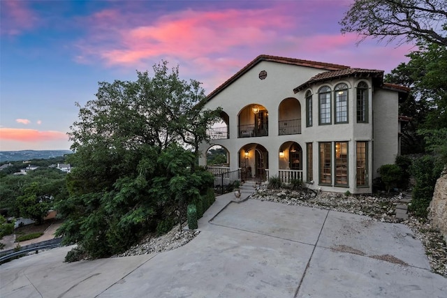 6203 Ledge Mountain Dr, Austin, TX 78731 - mediterranean / spanish-style house featuring a balcony, stucco siding, and covered porch