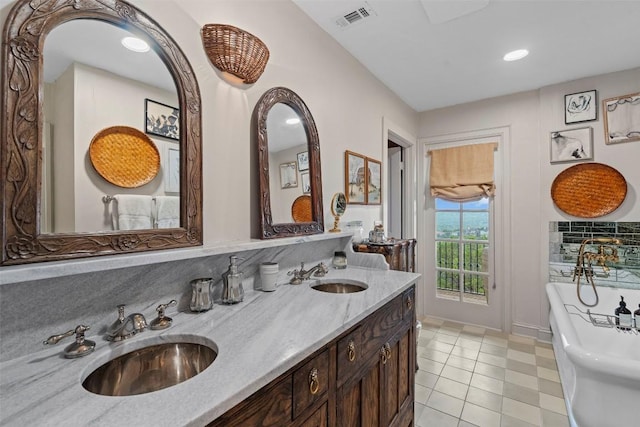 6203 Ledge Mountain Dr, Austin, TX 78731 - bathroom featuring a freestanding bath, double vanity, recessed lighting, tile patterned floors, and baseboards