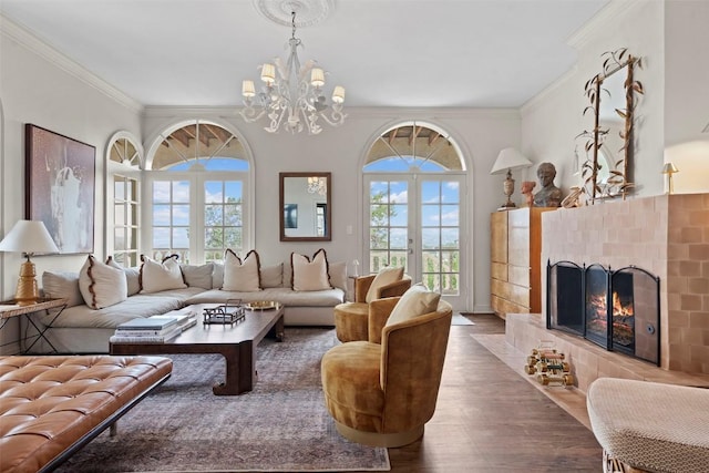 6203 Ledge Mountain Dr, Austin, TX 78731 - living area featuring a tiled fireplace, wood finished floors, ornamental molding, and a chandelier