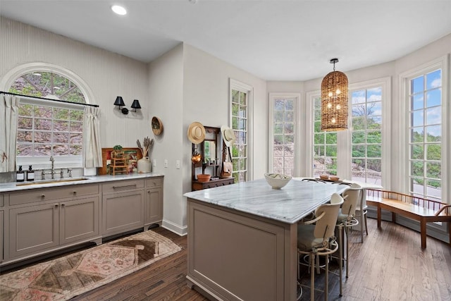 6203 Ledge Mountain Dr, Austin, TX 78731 - kitchen with a sink, gray cabinets, dark wood finished floors, a center island, and a breakfast bar