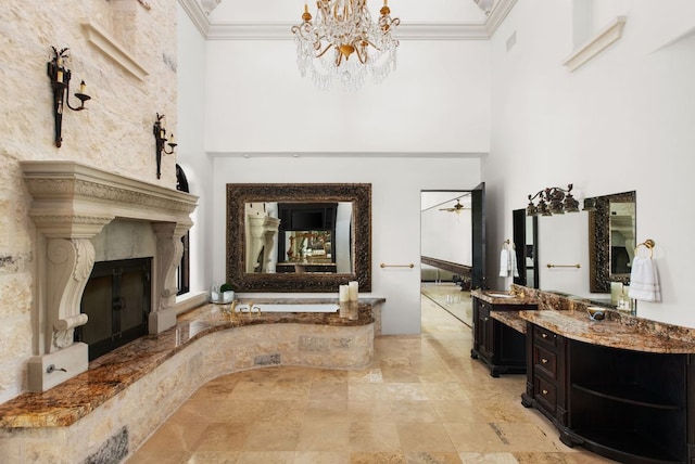 4256 Fischer Store Rd, Wimberley, TX 78676 - full bath featuring a fireplace with raised hearth, crown molding, a towering ceiling, vanity, and a chandelier