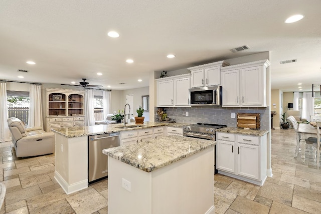 1705 Chinati Ct, Cedar Park, TX 78613 - kitchen featuring stainless steel appliances, a sink, stone tile floors, ceiling fan, and recessed lighting