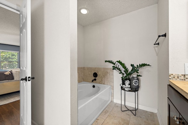 1705 Chinati Ct, Cedar Park, TX 78613 - full bathroom featuring a garden tub, a textured ceiling, vanity, and ensuite bathroom
