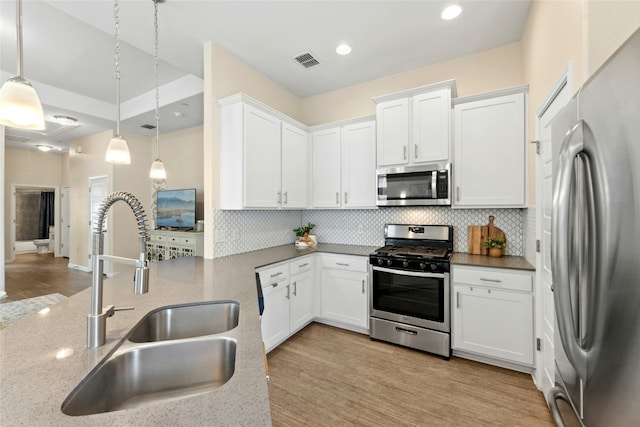 11805 Bracco Dr, Austin, TX 78748 - kitchen featuring stainless steel appliances, a sink, backsplash, hanging light fixtures, and light stone countertops