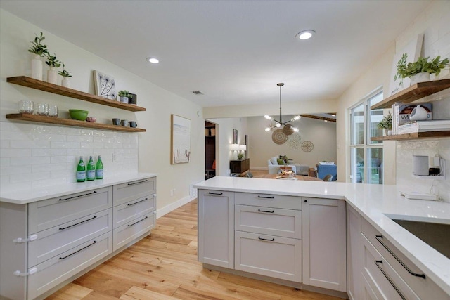 12801 Oak Bend Cv, Austin, TX 78727 - kitchen with open shelves, a peninsula, light wood finished floors, pendant lighting, and recessed lighting