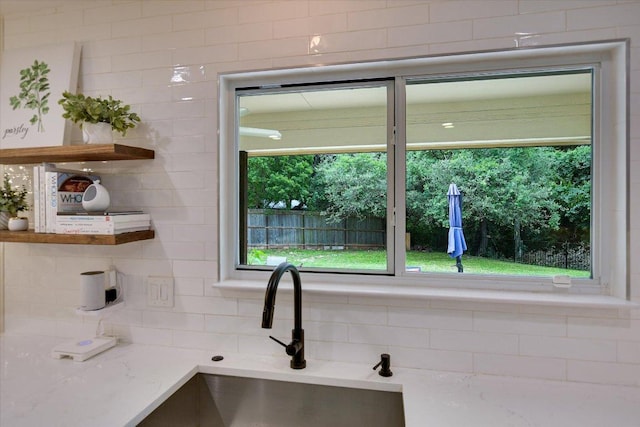 12801 Oak Bend Cv, Austin, TX 78727 - kitchen with open shelves, backsplash, a sink, and light stone countertops