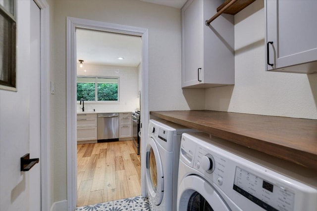 12801 Oak Bend Cv, Austin, TX 78727 - washroom with cabinet space, independent washer and dryer, and light wood finished floors