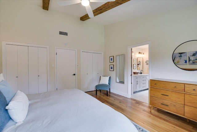 12801 Oak Bend Cv, Austin, TX 78727 - bedroom with two closets, a towering ceiling, light wood-type flooring, beam ceiling, and ensuite bathroom