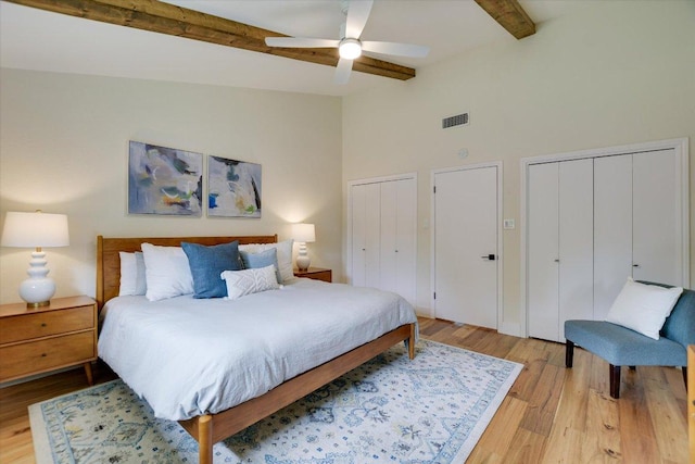 12801 Oak Bend Cv, Austin, TX 78727 - bedroom featuring two closets, beam ceiling, light wood-style floors, high vaulted ceiling, and ceiling fan
