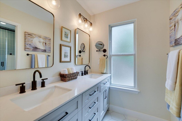 12801 Oak Bend Cv, Austin, TX 78727 - full bath with healthy amount of natural light, double vanity, tile patterned floors, and baseboards