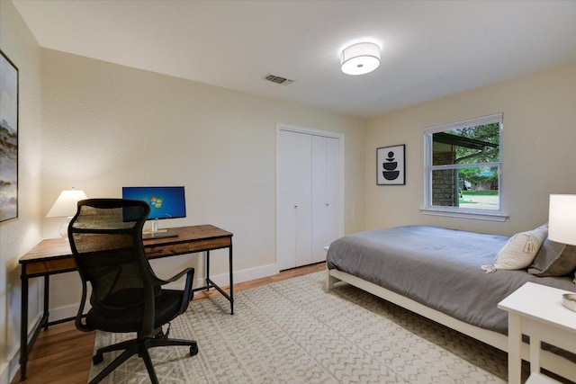 12801 Oak Bend Cv, Austin, TX 78727 - bedroom with light wood-style flooring, baseboards, an office area, and a closet