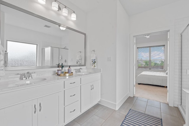 104 Meadow Wood Cv, Georgetown, TX 78626 - ensuite bathroom with a shower stall, double vanity, tile patterned flooring, and baseboards