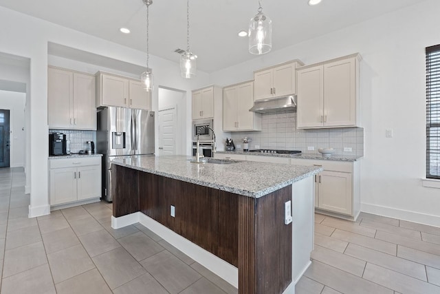 104 Meadow Wood Cv, Georgetown, TX 78626 - kitchen with appliances with stainless steel finishes, under cabinet range hood, backsplash, a sink, and pendant lighting