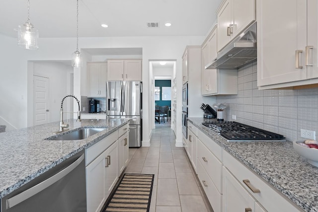 104 Meadow Wood Cv, Georgetown, TX 78626 - kitchen with stainless steel appliances, a sink, under cabinet range hood, backsplash, and light tile patterned flooring