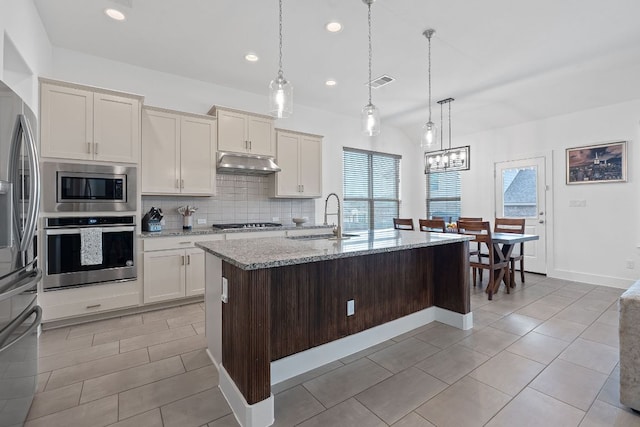 104 Meadow Wood Cv, Georgetown, TX 78626 - kitchen featuring appliances with stainless steel finishes, a sink, under cabinet range hood, plenty of natural light, and recessed lighting