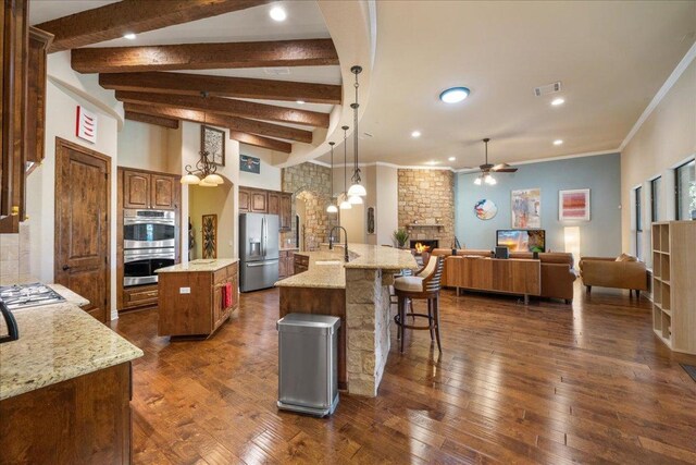 102 Standing Oak Dr, Georgetown, TX 78633 - kitchen featuring appliances with stainless steel finishes, a spacious island, ceiling fan, a fireplace, and open floor plan