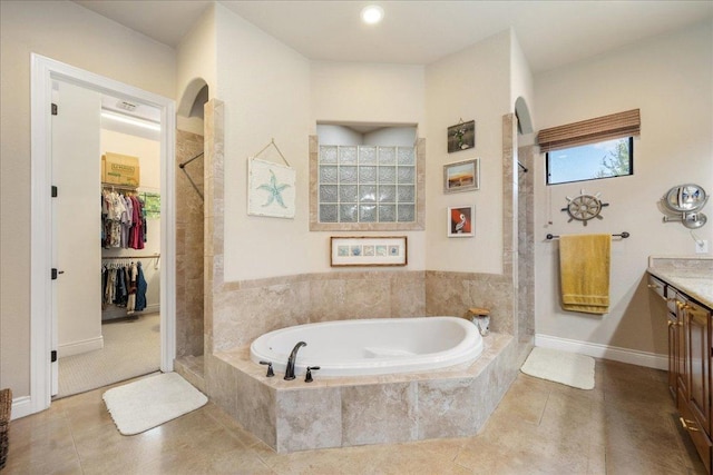 102 Standing Oak Dr, Georgetown, TX 78633 - bathroom with vanity, tiled shower, a bath, tile patterned floors, and a spacious closet