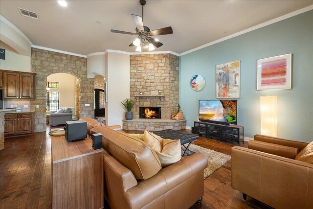 102 Standing Oak Dr, Georgetown, TX 78633 - living area with arched walkways, a ceiling fan, dark wood-style floors, ornamental molding, and a fireplace