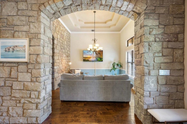 102 Standing Oak Dr, Georgetown, TX 78633 - living area featuring ornamental molding, hardwood / wood-style flooring, arched walkways, a chandelier, and a tray ceiling