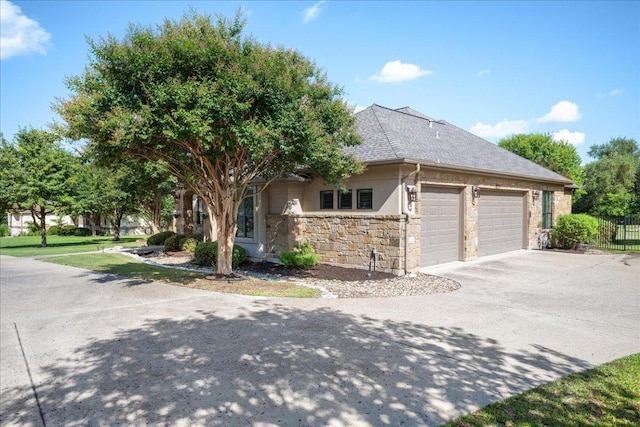 102 Standing Oak Dr, Georgetown, TX 78633 - view of property exterior with a garage, concrete driveway, stone siding, roof with shingles, and stucco siding