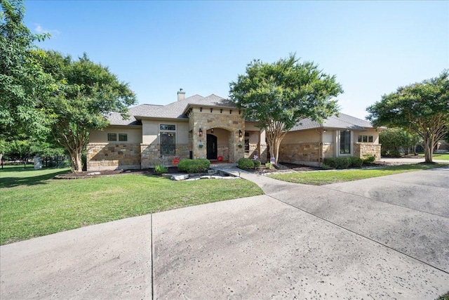 102 Standing Oak Dr, Georgetown, TX 78633 - view of front of home featuring stone siding, a front lawn, a chimney, and stucco siding