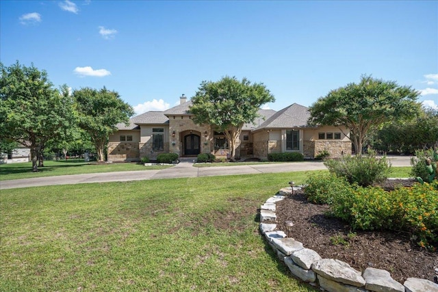 102 Standing Oak Dr, Georgetown, TX 78633 - view of front of property with stone siding, a front yard, a chimney, and french doors