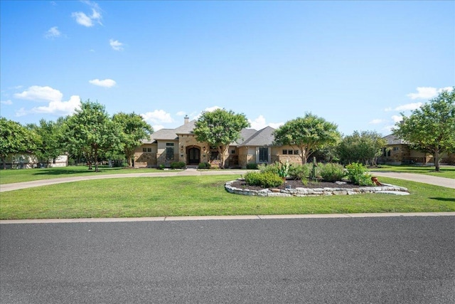 102 Standing Oak Dr, Georgetown, TX 78633 - view of front of home with curved driveway, stone siding, and a front lawn