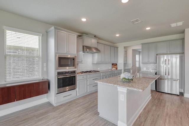 3241 Aurelia Ln, Round Rock, TX 78665 - kitchen with appliances with stainless steel finishes, gray cabinetry, under cabinet range hood, backsplash, and recessed lighting