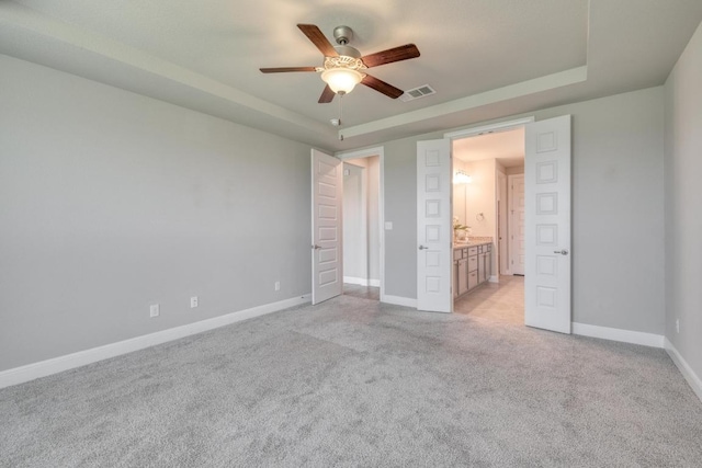 3241 Aurelia Ln, Round Rock, TX 78665 - unfurnished bedroom featuring a raised ceiling, light carpet, baseboards, and ceiling fan