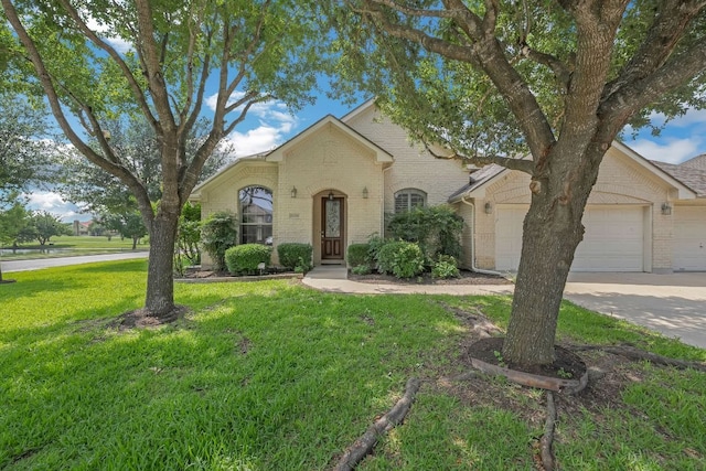 20700 Windmill Ridge St, Pflugerville, TX 78660 - traditional-style house featuring brick siding, a garage, a front yard, and concrete driveway