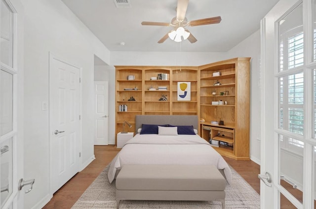 20700 Windmill Ridge St, Pflugerville, TX 78660 - bedroom with multiple windows, wood finished floors, and a ceiling fan