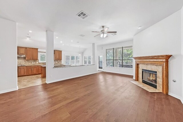 20700 Windmill Ridge St, Pflugerville, TX 78660 - unfurnished living room featuring ceiling fan, a tile fireplace, wood finished floors, and recessed lighting