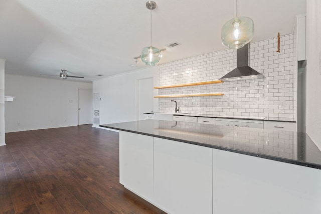 1510 W N Loop Blvd Unit 424, Austin, TX 78756 - kitchen with wall chimney range hood, backsplash, white cabinetry, and dark wood-style flooring