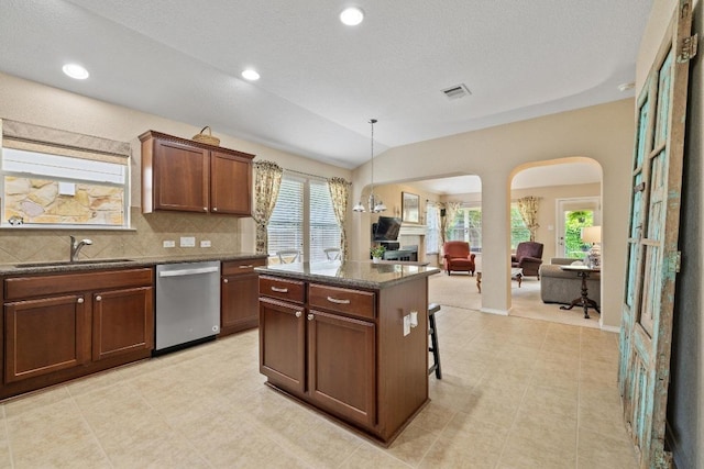 11208 Persimmon Gap Dr, Austin, TX 78717 - kitchen featuring dishwasher, arched walkways, a sink, a center island, and decorative backsplash