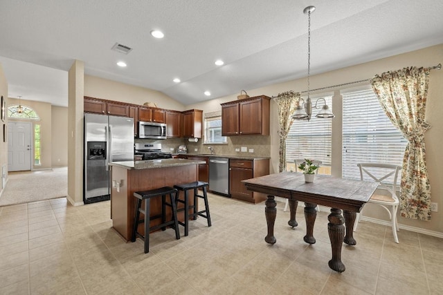 11208 Persimmon Gap Dr, Austin, TX 78717 - kitchen featuring appliances with stainless steel finishes, a kitchen island, a chandelier, vaulted ceiling, and healthy amount of natural light