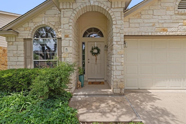 11208 Persimmon Gap Dr, Austin, TX 78717 - property entrance featuring stone siding, a garage, and concrete driveway