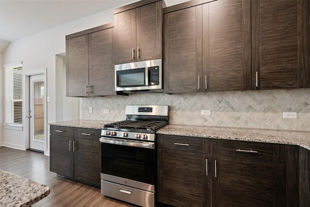 605 Bridle Creek Dr, Georgetown, TX 78626 - kitchen with appliances with stainless steel finishes, dark brown cabinetry, and decorative backsplash