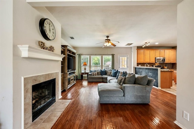 17121 Bishopsgate Dr, Pflugerville, TX 78660 - living room featuring ceiling fan, hardwood / wood-style floors, and a tiled fireplace