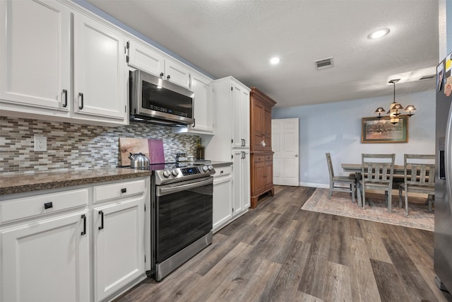 1250 S Rainbow Ranch Rd, Wimberley, TX 78676 - kitchen with appliances with stainless steel finishes, a chandelier, white cabinets, backsplash, and a textured ceiling