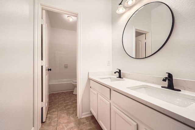 9812 Whitley Bay Dr, Austin, TX 78717 - full bathroom with double vanity, tile patterned flooring, toilet, and baseboards