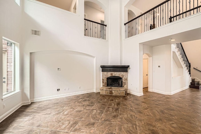 9812 Whitley Bay Dr, Austin, TX 78717 - unfurnished living room featuring a towering ceiling, a fireplace, baseboards, and stairway